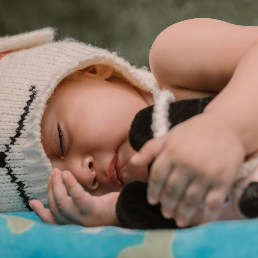 Peaceful baby sleeping in a cute knitted hat. Perfect for cozy, comforting themes.